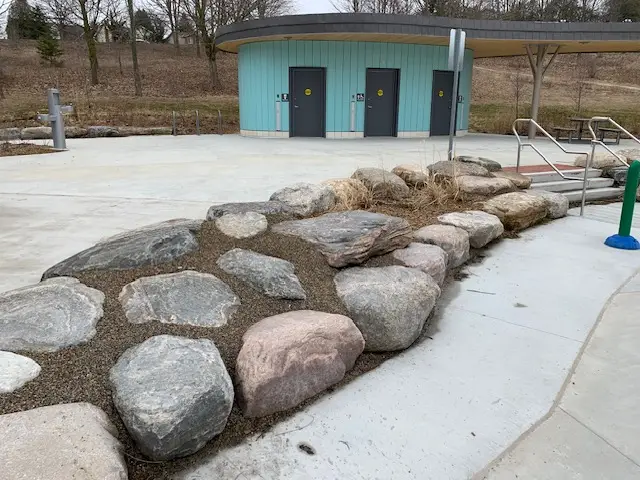 permeable resin bound aggregate fills voids caused by boulder design in Guelph